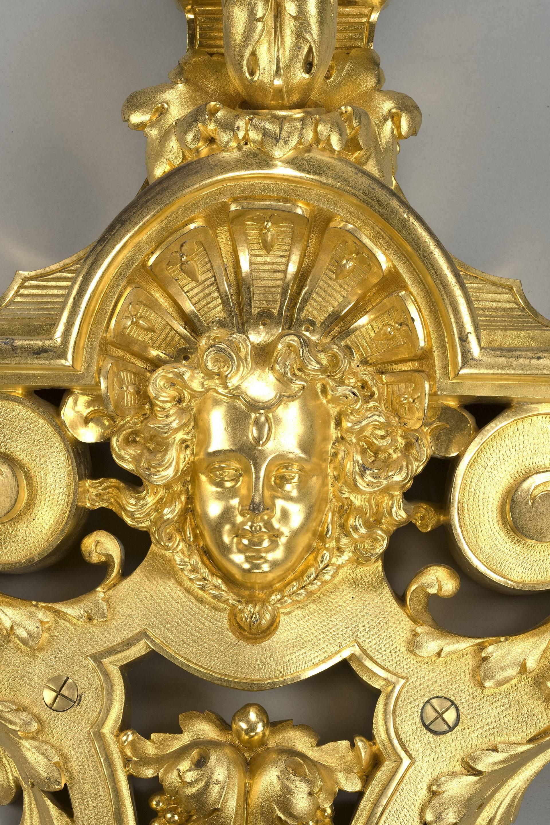 A set, each of these four fine French gilt wall lights includes a strapwork cartouche centred on a female mask below a leaf and urn finial and four supporting c-scroll brackets. Signed ‘Rode a Paris’. Circa 1890. 