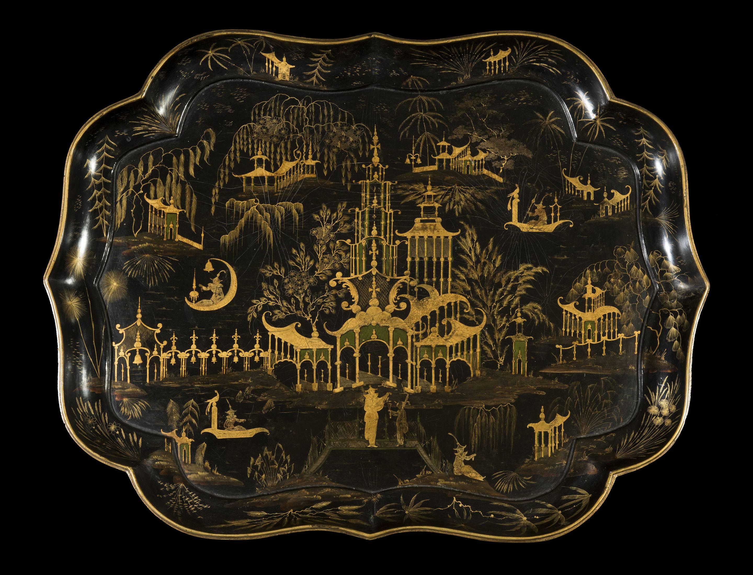The shapely and finely decorated black papier-mâché tray with chinoiserie decoration is supported on a later ebonized faux-bamboo stand and can be easily detached. The gilt lacquer chinoiserie decoration is of the highest quality and depicts the far