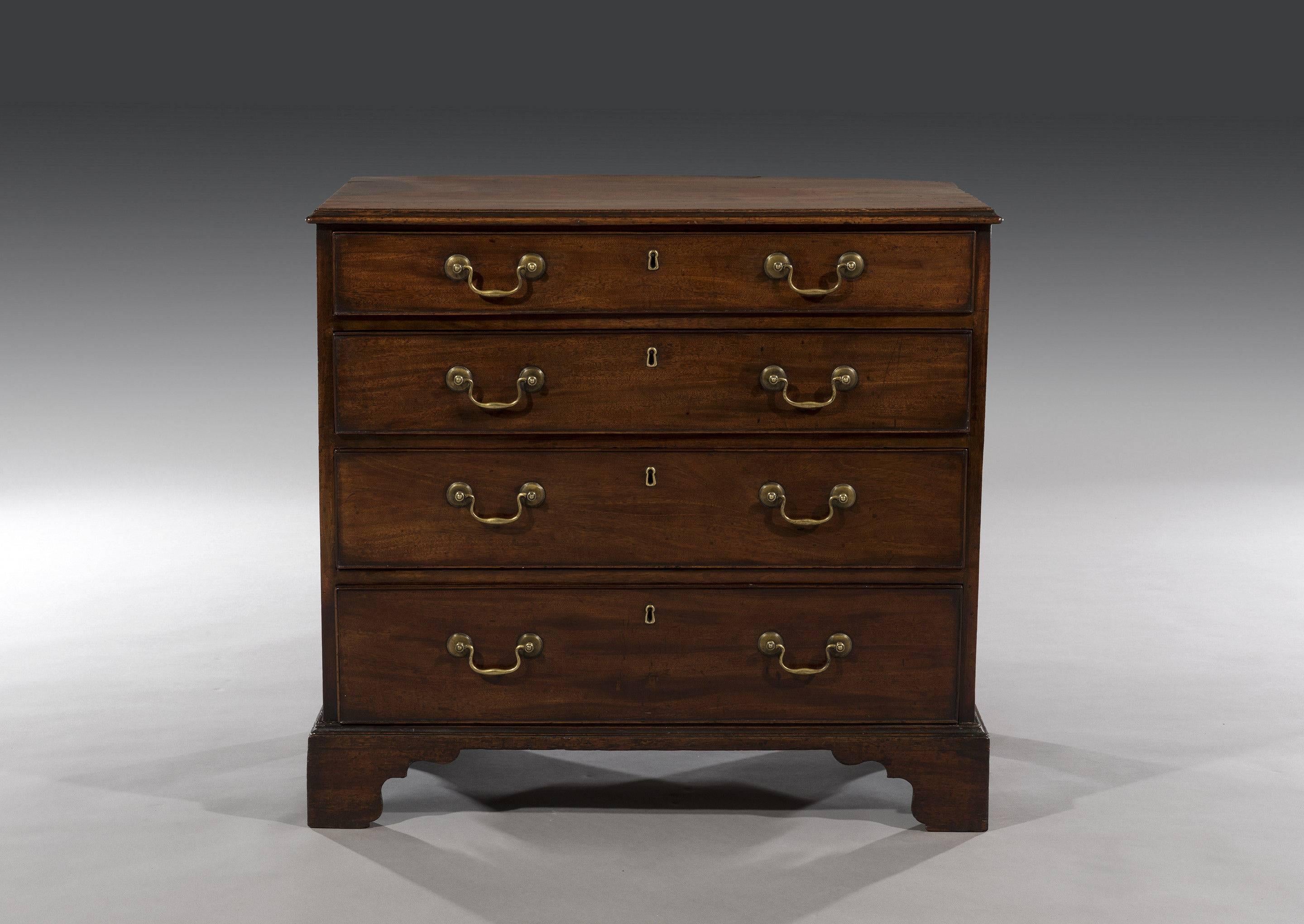 The mahogany chest has a rectangular top above four long graduated oak lined drawers and is fitted with the original brass back plates and escutcheons with some replaced brass swan neck handles. The chest stands on ogee bracket feet.