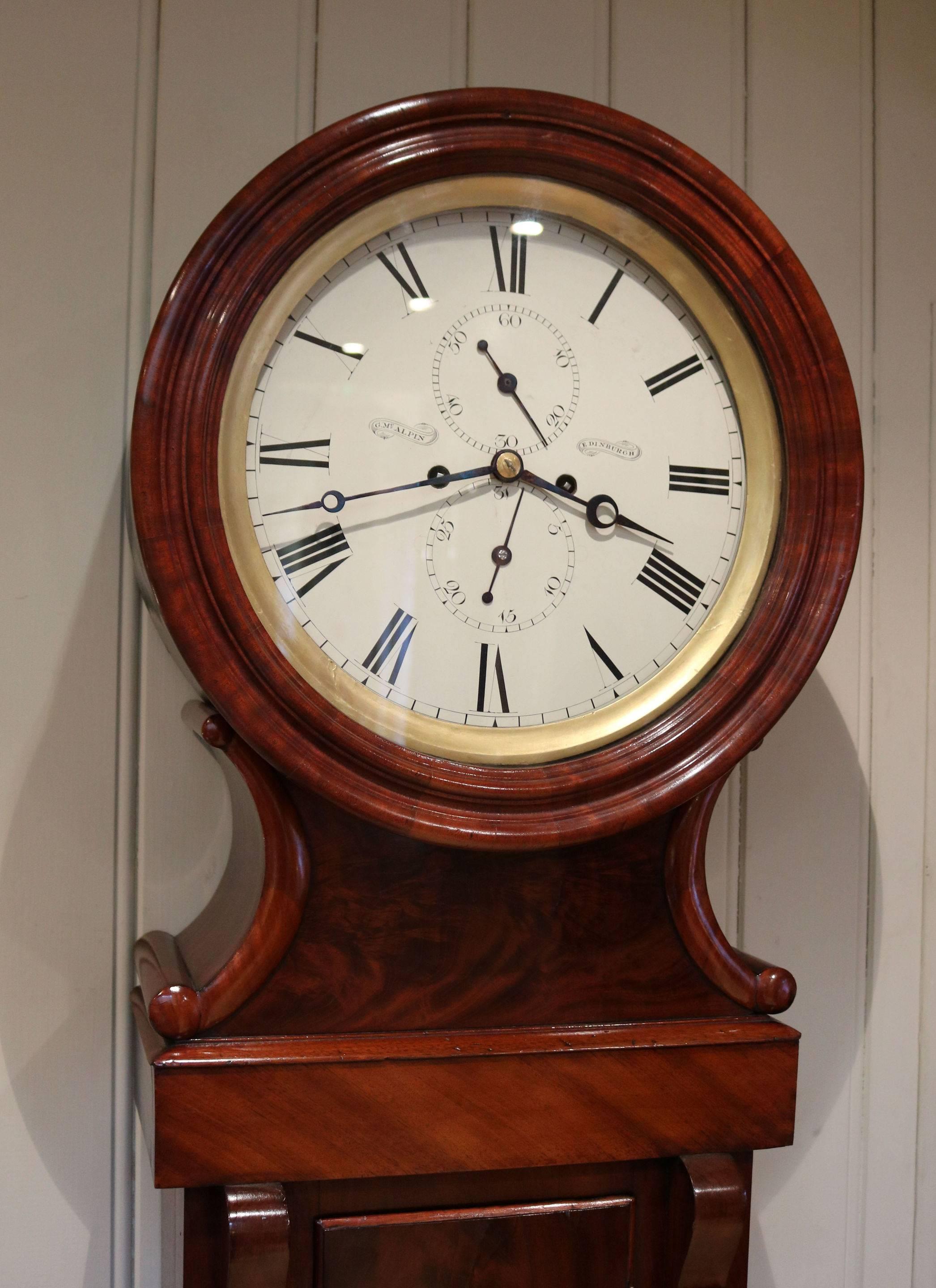 An original Mahogany longcase clock made in the first half of the 19th century. It has a typical Edinburgh drumhead case, with a nicely figured door base and intermediate sections. The lift up circular door has a gilt sight ring. The white enamel