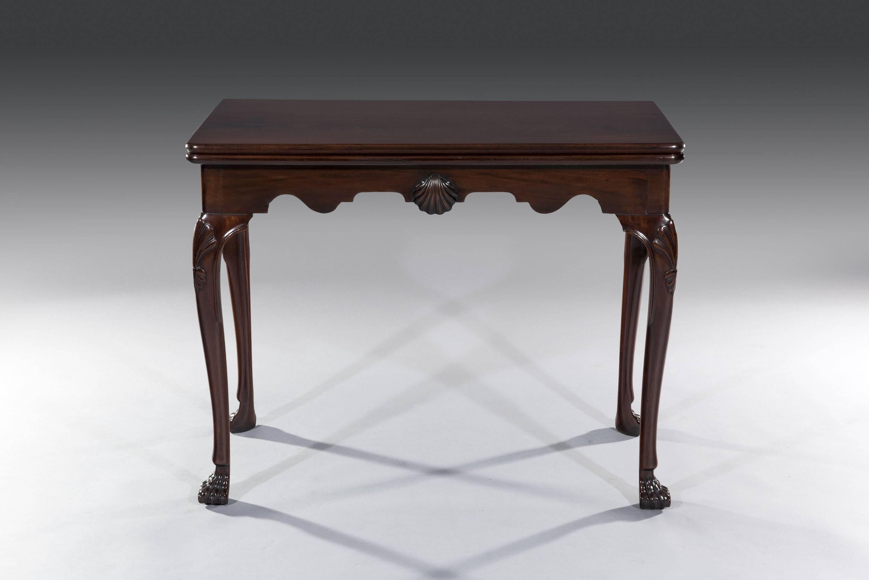 The solid Cuban mahogany rectangular top has a figured grain and retains a deep color and patination. The top lifts up to reveal a green baize playing surface which is supported by a single gate-leg action leg at the back. The frieze is shaped and