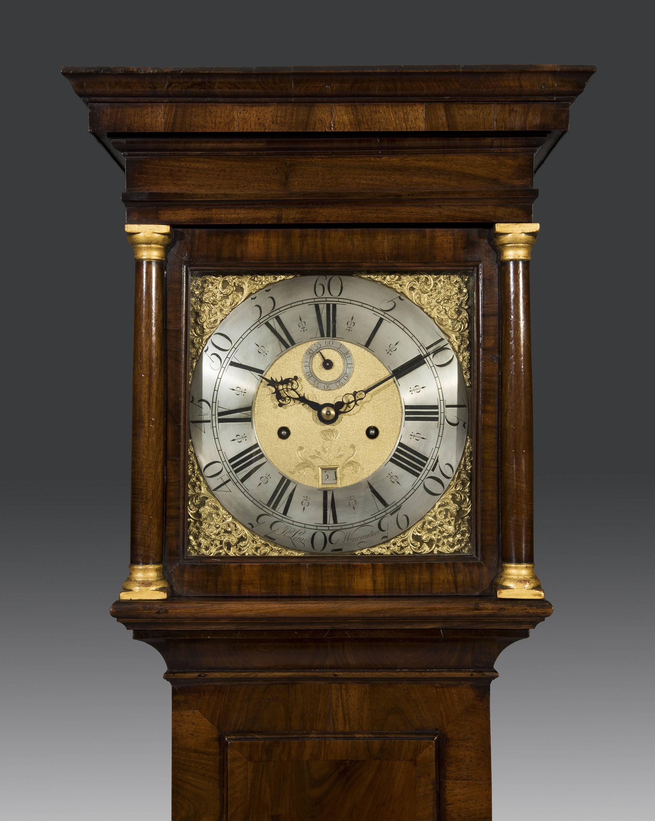 The walnut brass dial 8 day longcase clock by Richard Lewis of Wincanton is of slender elegant proportions and retains a warm golden colour. The five pillar movement strikes the hour on a bell and is mounted on a rare 11” brass dial with a silver