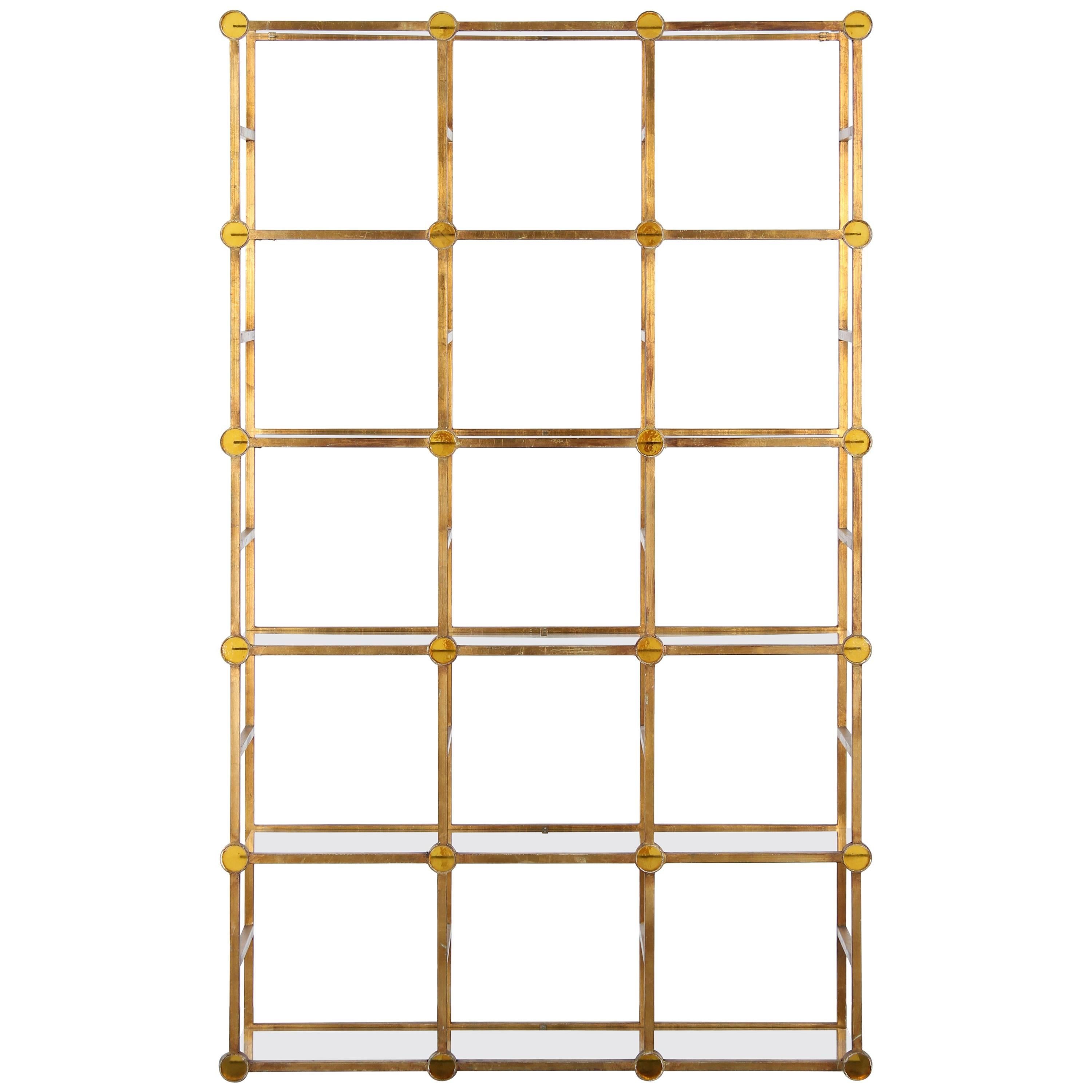 An amazing gilded iron étagère shelving unit. Its stunning architectural design features 24 yellow glass rondelles. Shelving unit is in good condition, some chips to glass shelves.