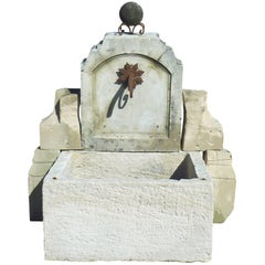 Rustikaler Garten-Wandbrunnen mit antikem Steingefäß und Eisenroste, Provence