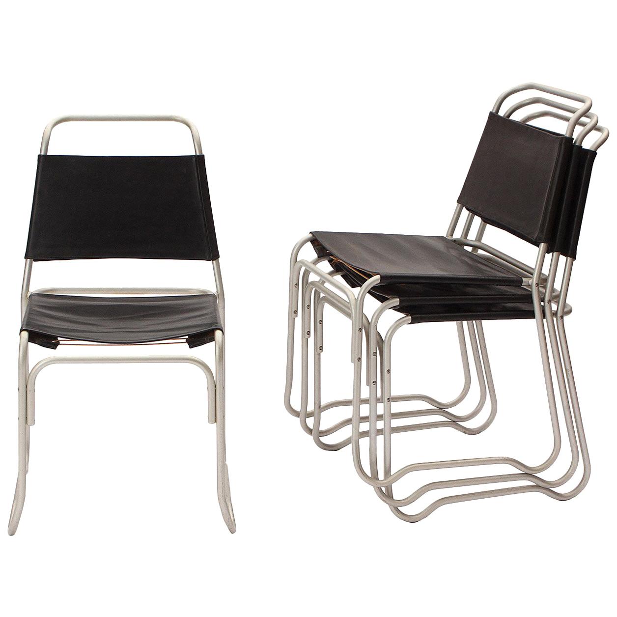 A stacking chair designed by Jack Heaney featuring sculptural frames of tubular aluminum with black leatherette sling seats and back rests. Part of the permanent design collection of MoMA. Designed by Heany in 1947, made by Treitel - Gratz Co. in