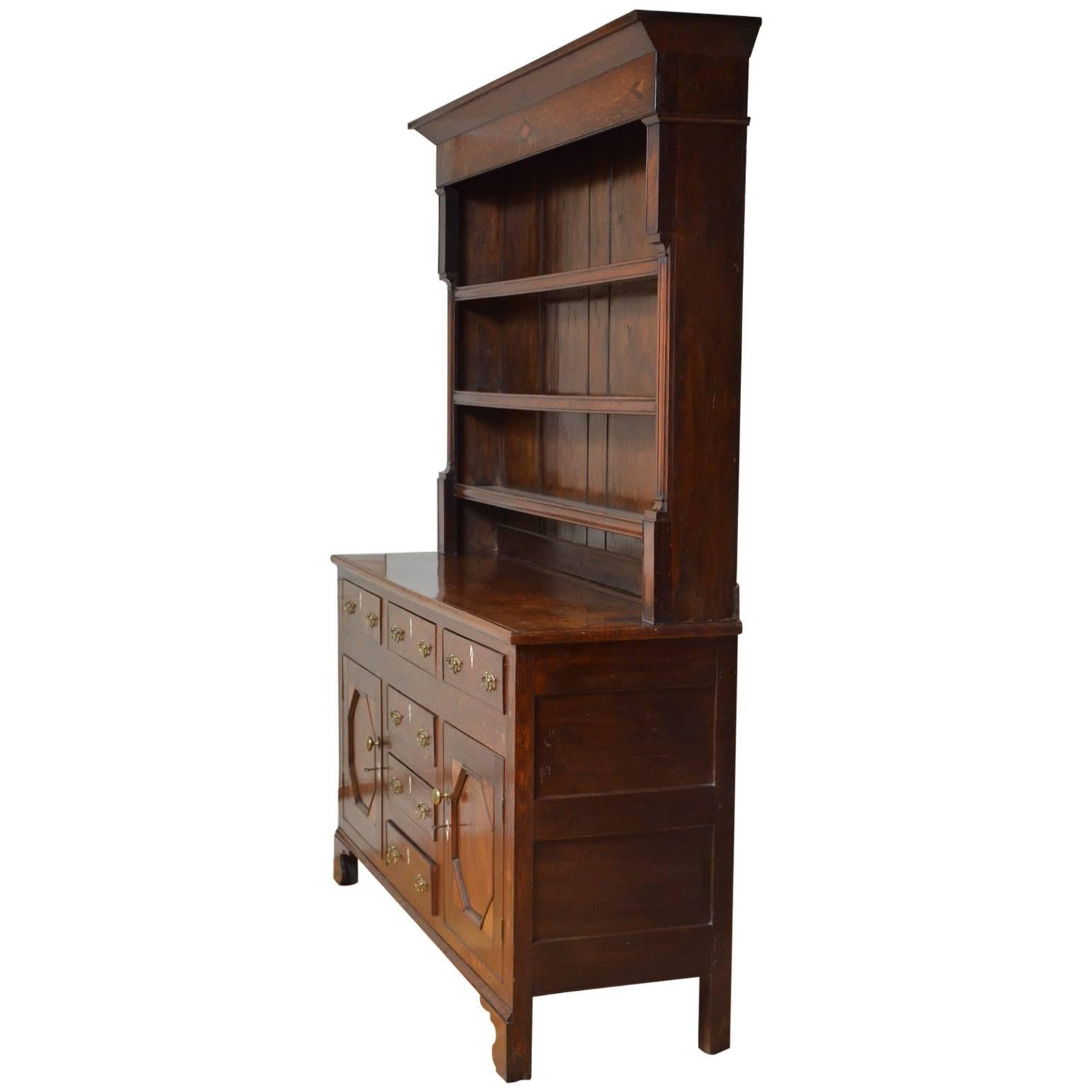 Sn4302 George III oak and mahogany Welsh dresser, having plate rack to back with outswpet cornice over inlaid frieze, three shelves with thumb moulded fronts, flanked by figured mahogany panels and shaped pilasters. The base having three inlaid and