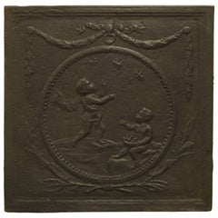 Plaque de cheminée ancienne avec deux Cupidons en cercle