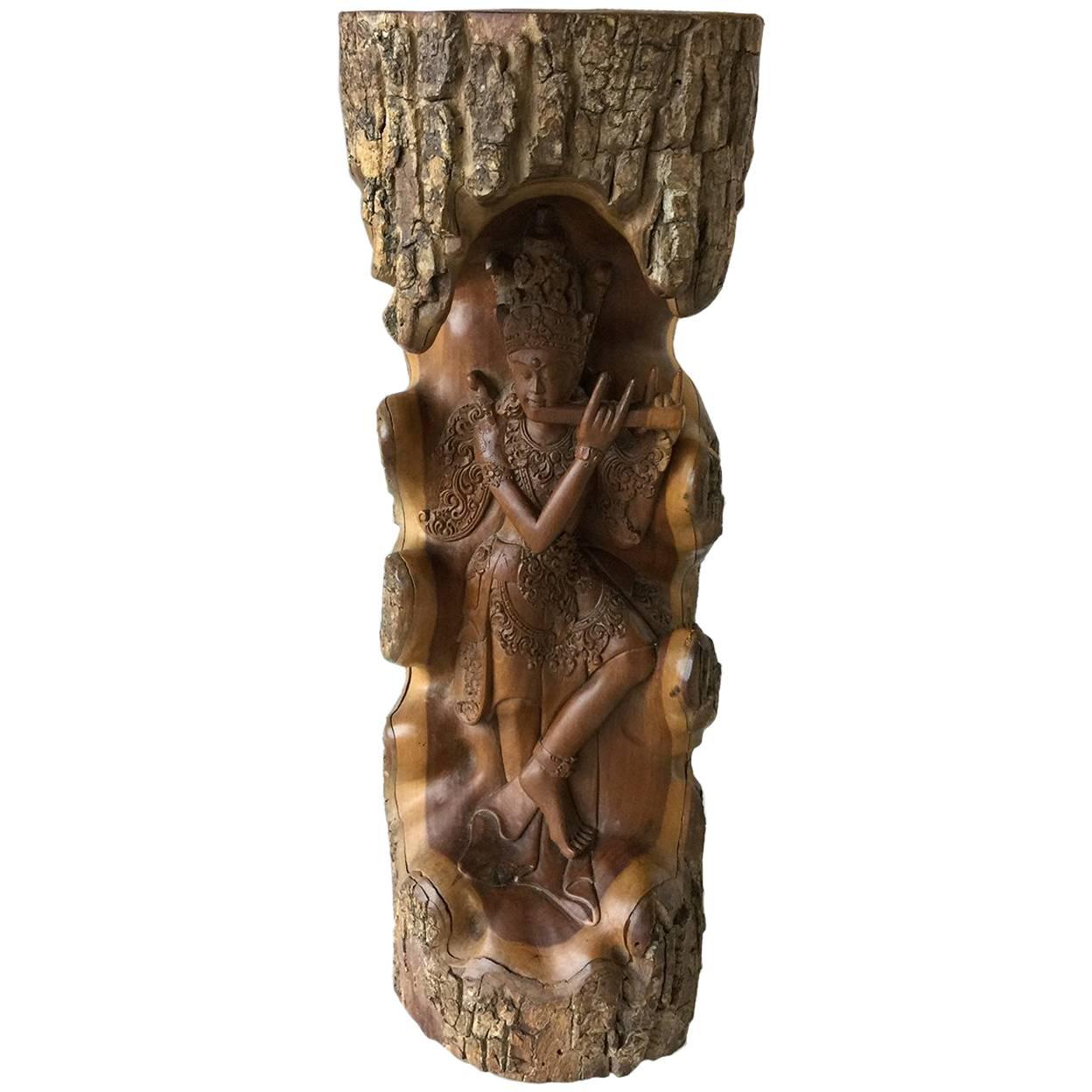 Hand-carved wooden statue with Lord Krishna from a piece of a tree For Sale