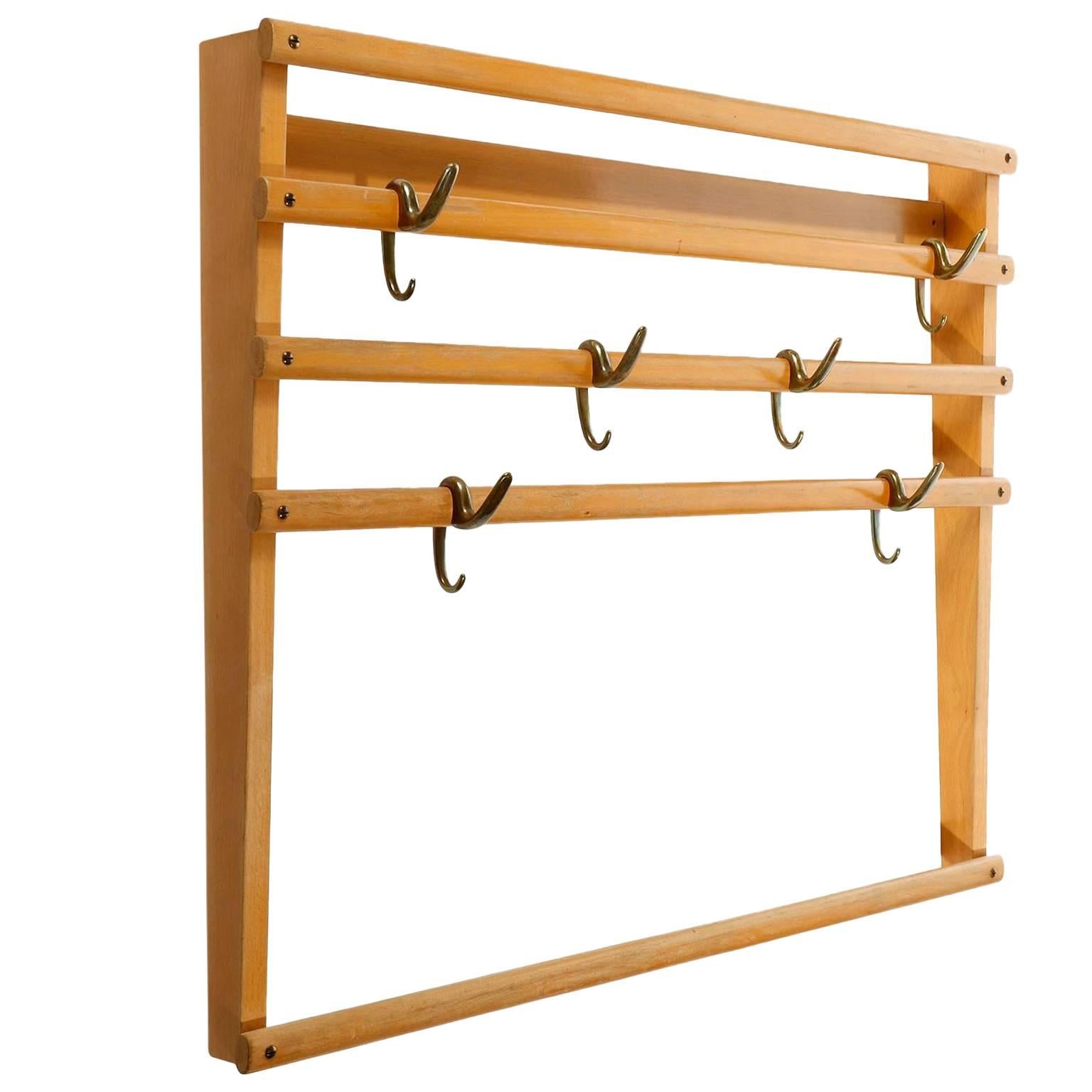 A wardrobe by Carl Auböck, Vienna, Austria, manufactured in midcentury, circa 1950.
It is made of a beech wood frame in an aged and very warm tone. There are six patinated brass hooks (similar to bronze) which can be positioned randomly on the