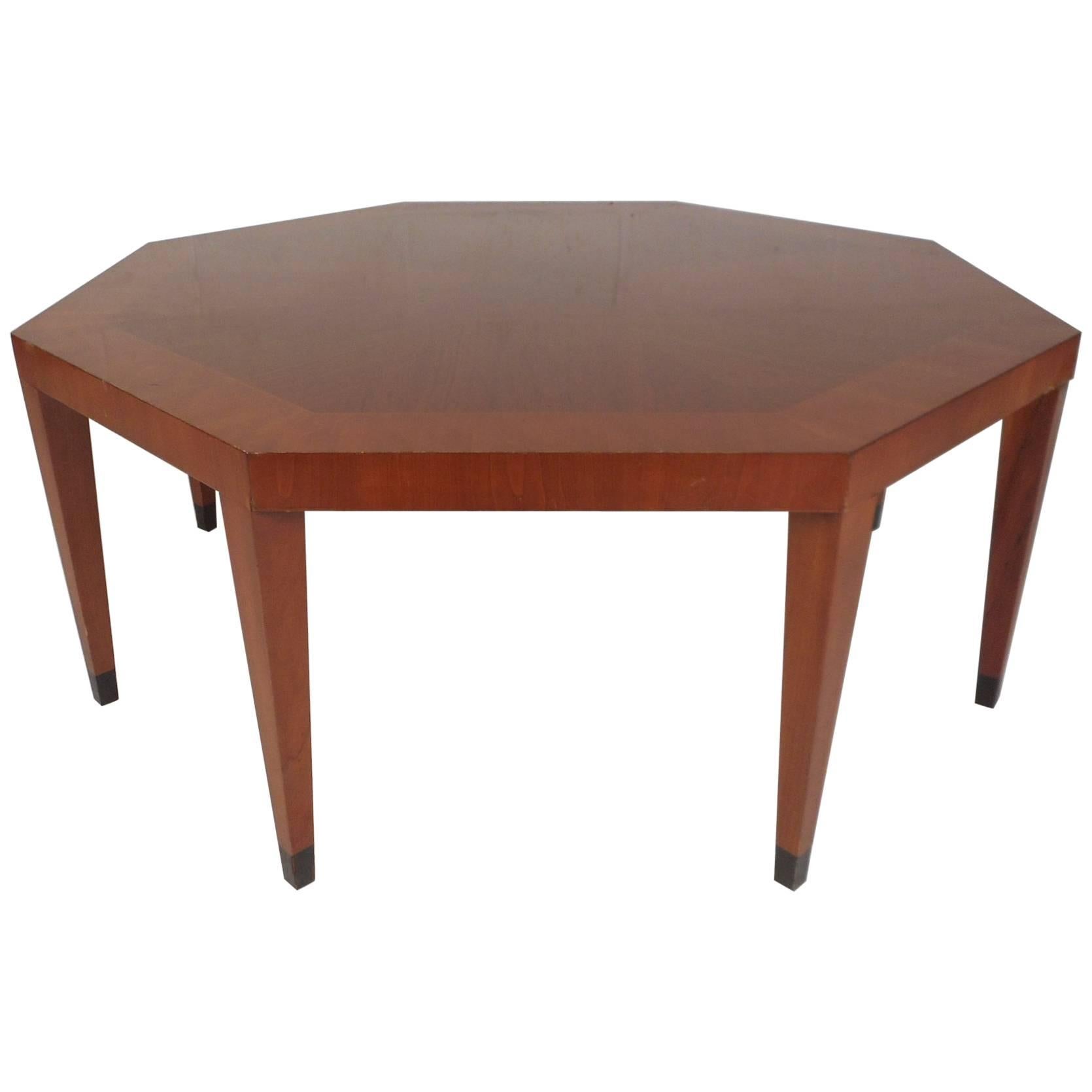 Stunning Mid-Century Modern coffee table with an octagonal shape and a two-tone top. Sleek design with wood grain running in different directions on top adding to the allure. Quality craftsmanship with eight removable tapered legs and elegant walnut