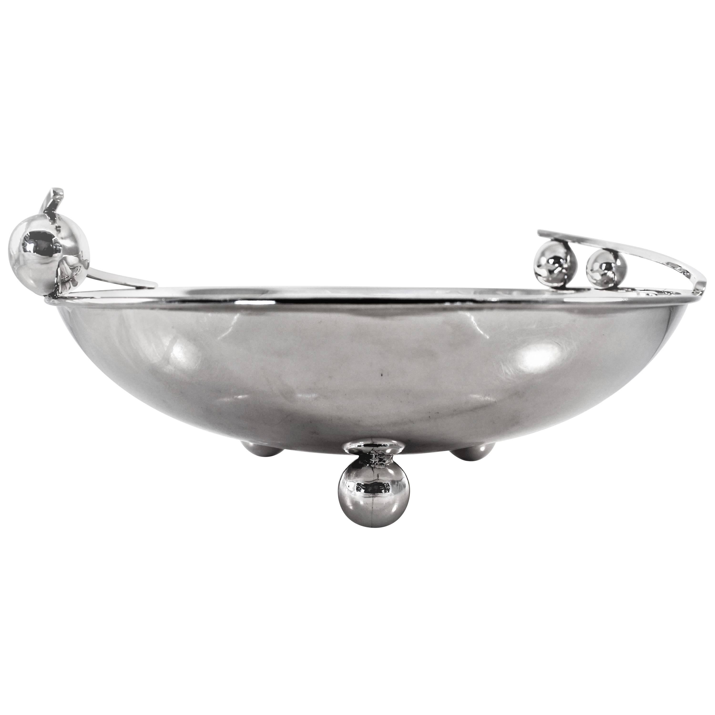 We’re absolutely crazy over this uber-modern large bowl. It has a Danish / Jensen-esque look to it. There are three large balls on the bottom, raising it off the surface. On each side of the top, a piece of silver jets out from the bowl and is held