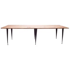 Auf Bestellung gefertigter Tisch mit aufgearbeiteter Eichenholzplatte und konisch zulaufenden schwarzen Eisenbeinen
