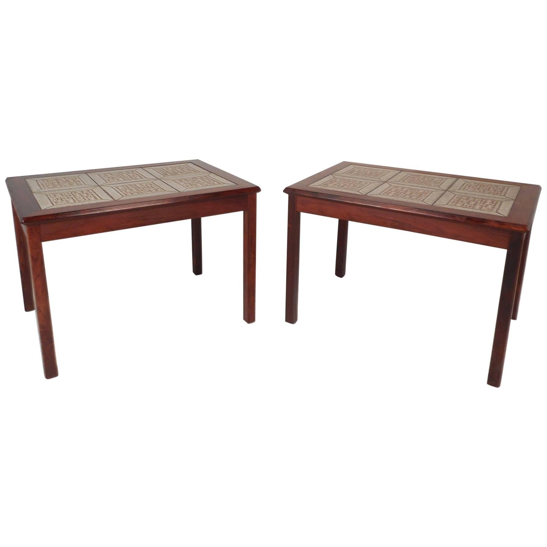 A fabulous pair of rosewood end tables with rosewood frames and a decorative tiled top. These beautiful pieces are stamped, 