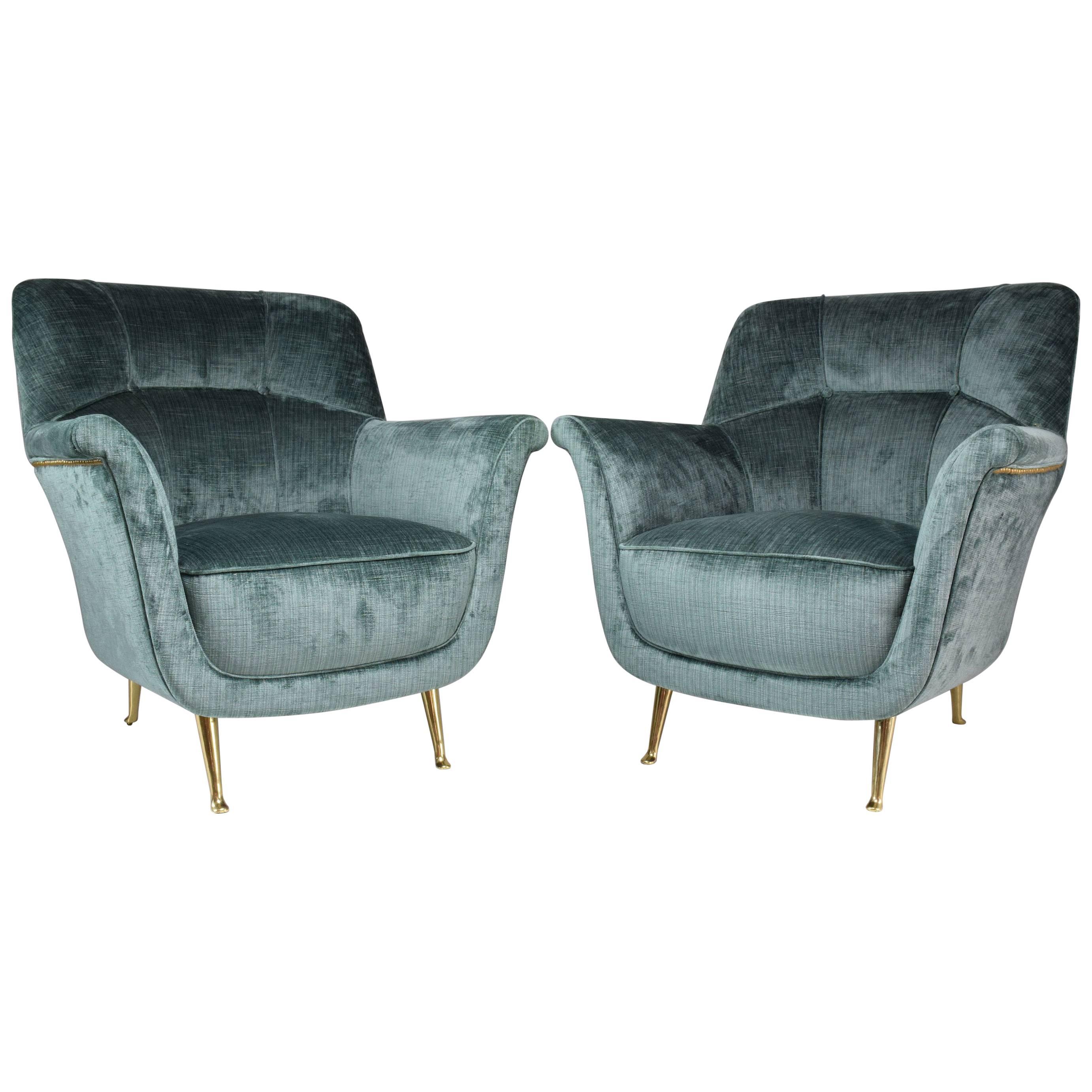 Set of two Italian 20th century vintage collectable armchairs manufactured by ISA Bergamo.
These midcentury design lounge chairs are highlighted by the winged arms, quilted backrest with gold nailhead trim and the iconic slender gold brass