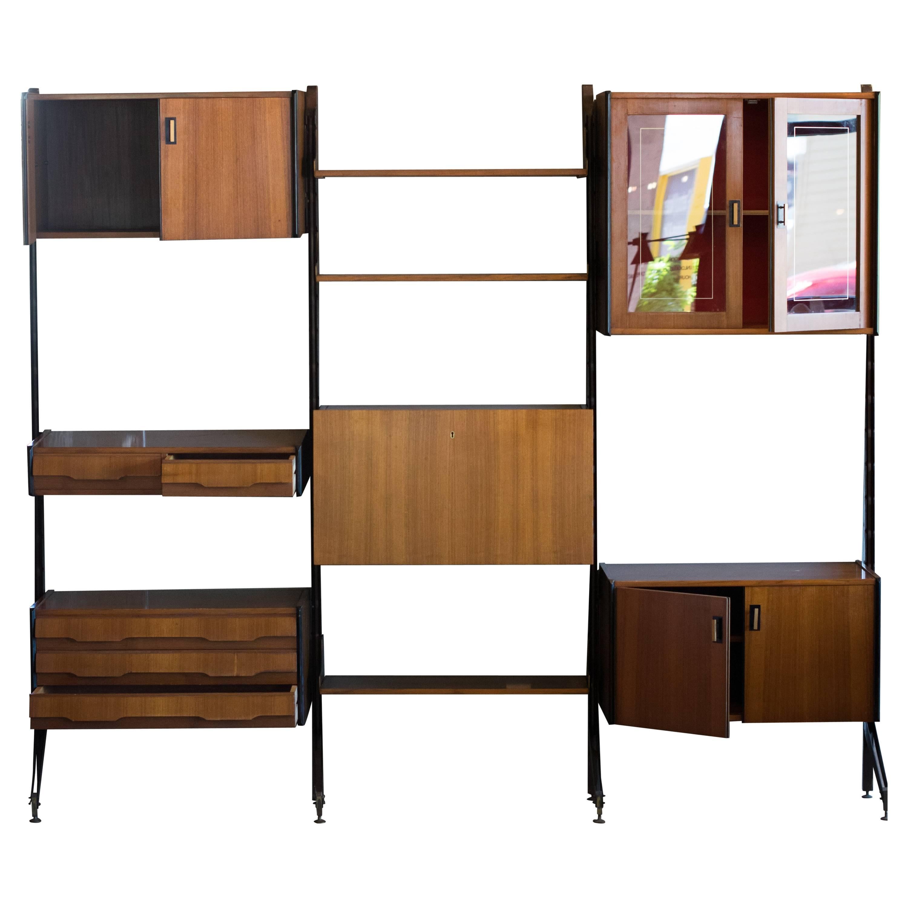 Bookcase and storage wall unit. Steel risers support teak shelves and cases with steel and brass hardware. Fully adjustable and freestanding. Cases and shelves can be reconfigured to create multiple arrangements, Italy, 1950s.

Includes three