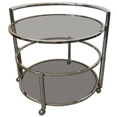 Mesa auxiliar o de centro redonda de mediados de siglo, de dos alturas, extensible, cromada y de cristal ahumado