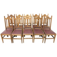 Liberty & Co, Ten Arts & Crafts Oak Dining Chairs with Stylised Floral Details