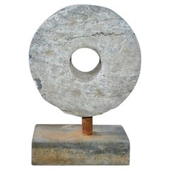 Pequeña escultura contemporánea de piedra de molino sobre peana
