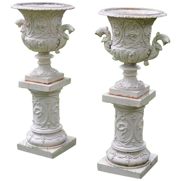 Pair of White Painted Cast-Iron Urns on Pedestals
