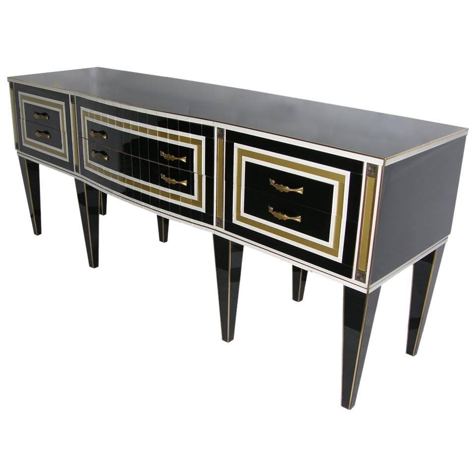 Italian sideboard of Art Deco Design, entirely hand crafted, the whole surround in opaline black glass with many quality details, exquisite craftsmanship and original hardware. This piece is whole brass edged and the front, with an elegant and