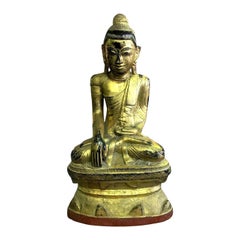 Grande Buddha di legno intagliato, laccato e dorato, seduto in un tempio santuario tailandese o birmano