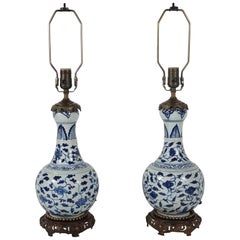 Paire de vases chinois à tête de garlic bleu et blanc accentués de bronze montés comme lampes