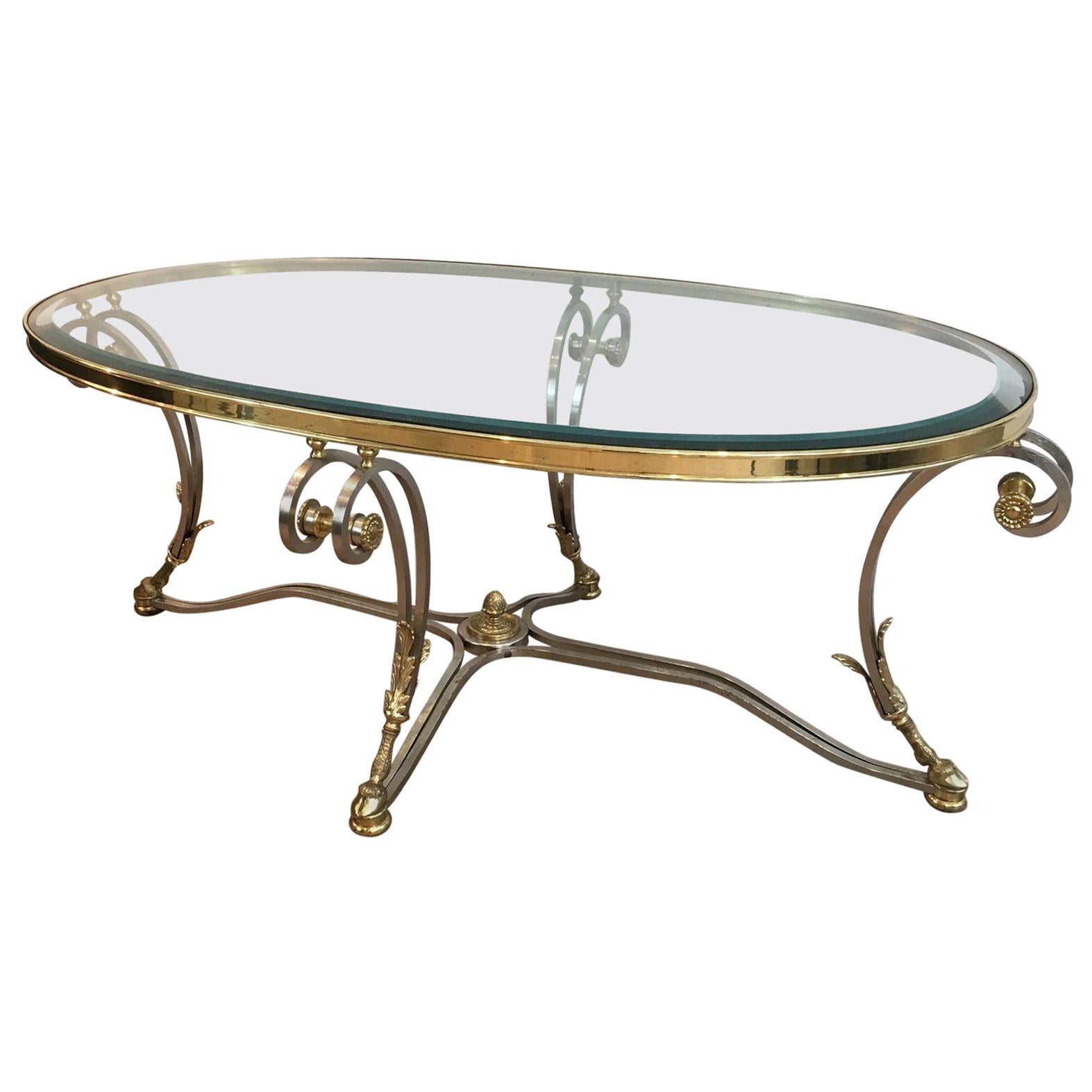 Magnifique table basse ovale en acier brossé et laiton de style néoclassique. Circa 1970