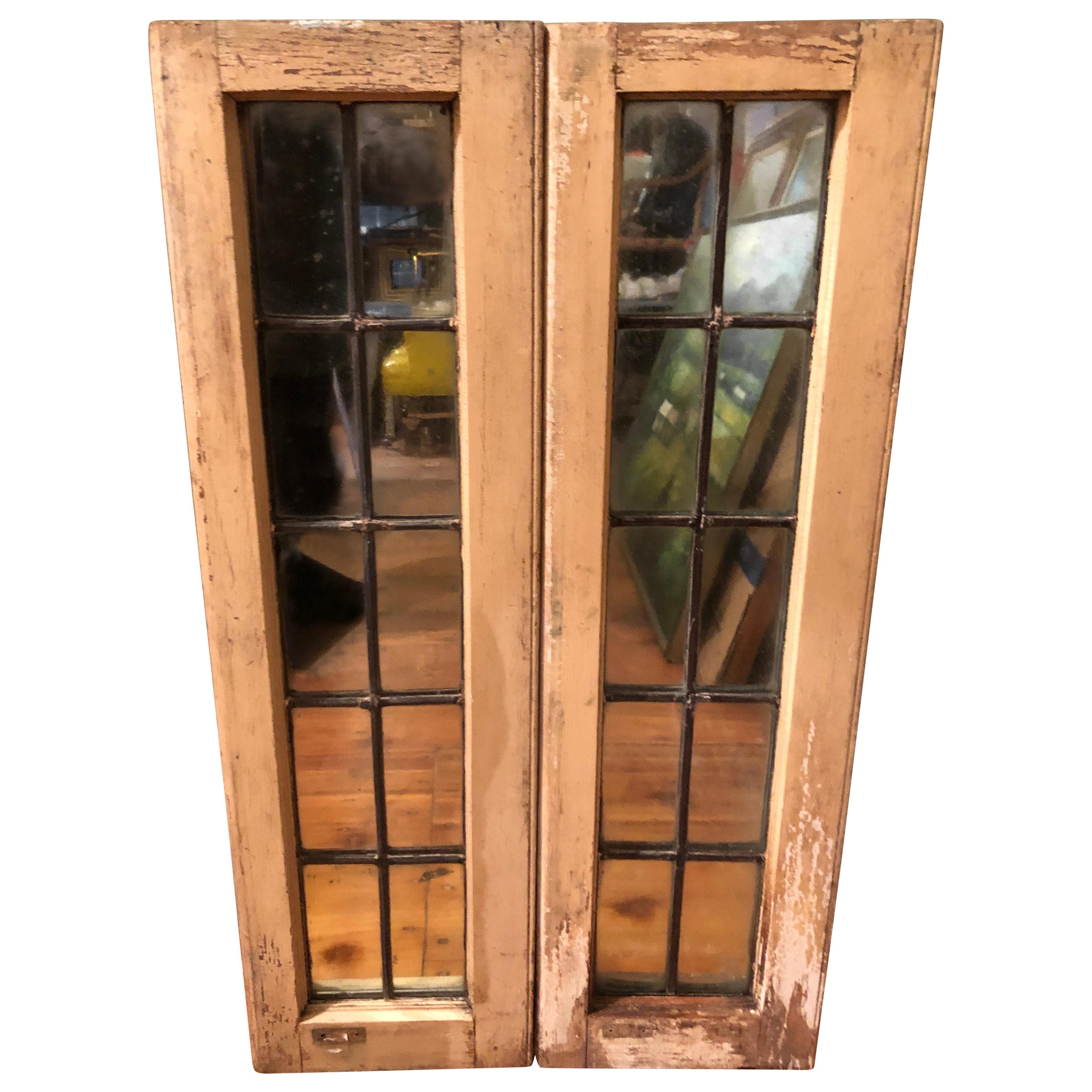 Pair of Shabby Chic leaded glass mirrors. Nice architectural pieces to install in a country home or just hang on the wall to give a room depth. Cream colored chippy paint and leaded grills. Each window is wired to hang vertically. Can be wired to