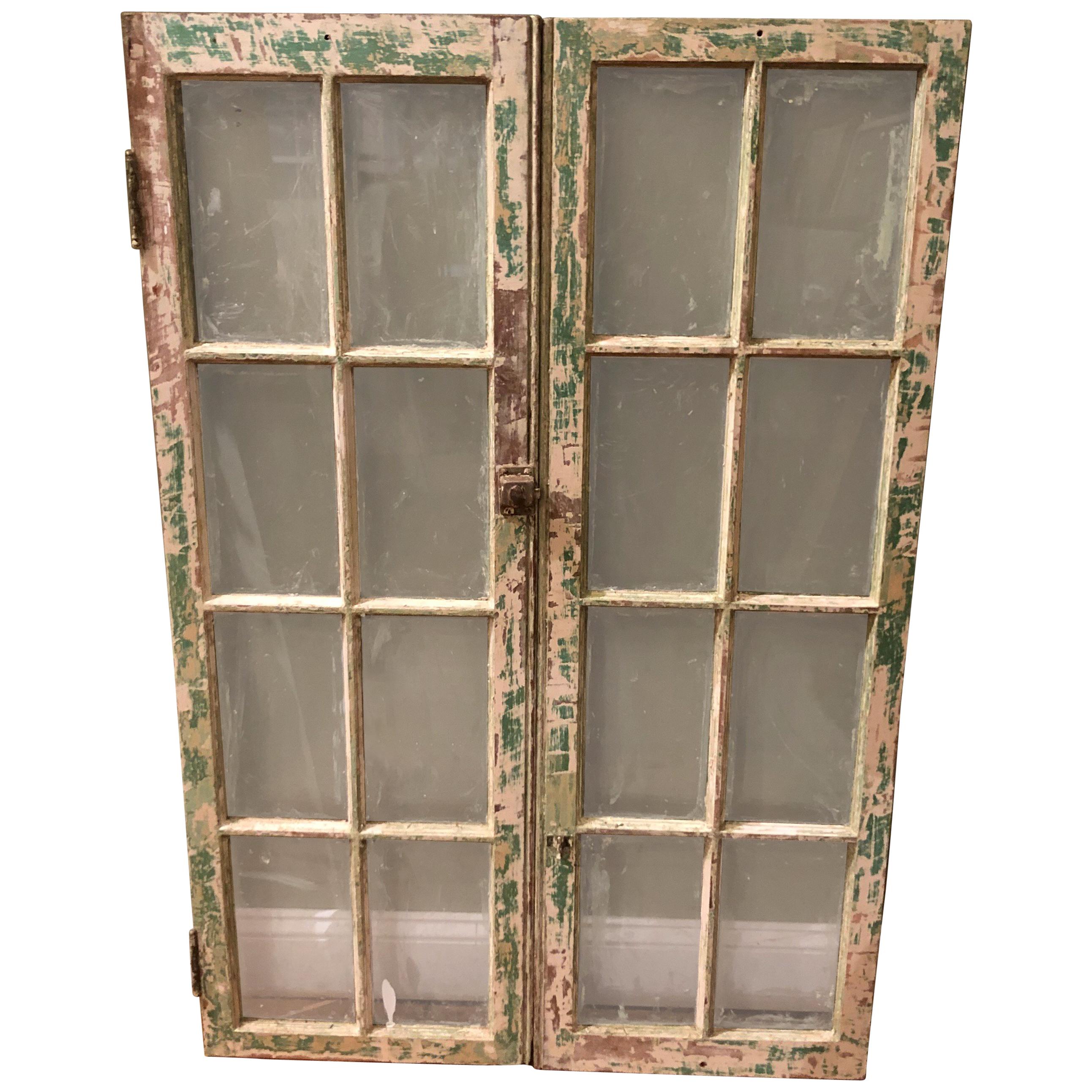 Pair of antique windows with distressed green paint finish. Use as real windows or add a mirror back to them and hang on a wall. Great architectural pieces for a farmhouse or country style home. Pair measures: 48.25 H x 32.25 W x 1.50 D. Each window