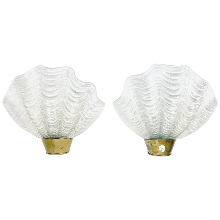 Two single sea shell sconces, 1950s, Sweden, a brass base with a detachable glass 