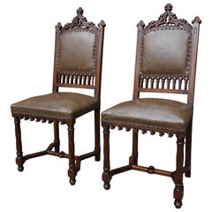 Paar handgeschnitzte Stühle aus massivem Nussbaumholz im gotischen Stil mit Lederpolsterung