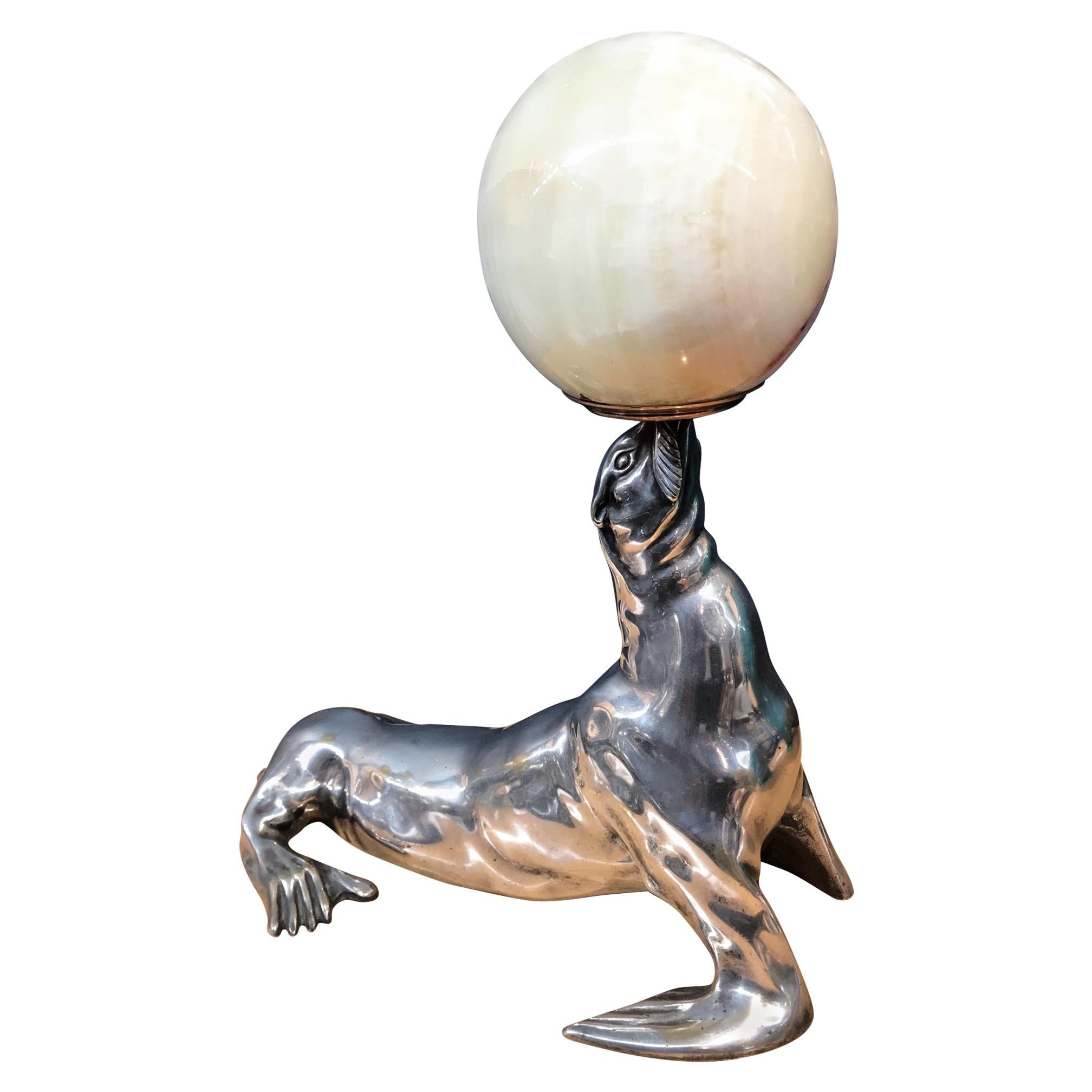 Luminaire bronze argenté éclairé  Sculpture représentant un sceau tenant un boulet d'onyx