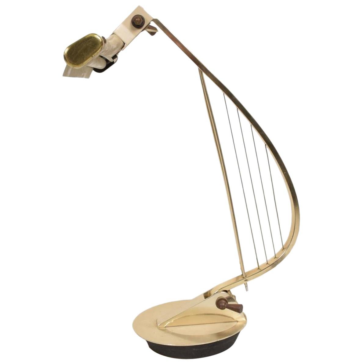 Desk Lamp
Mid Century Modern Brass Table Desk Task Lamp in a sculptural harp shape.
Made in the USA circa the 1960s. Metal Brass and Aluminum. Style of Lightolier.
Dimensions: 15H x 9.5 D x 12W.
Original vintage unrestored condition. Minor scuffs