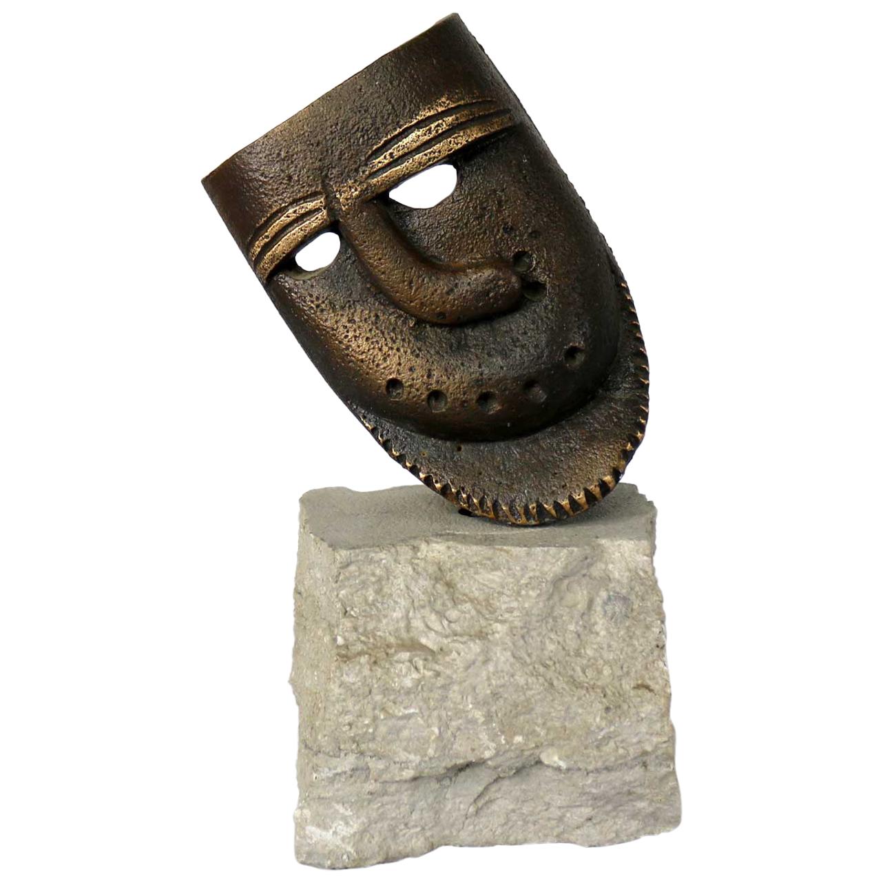 Cast Bronze African Mask Sculpture with Crooked Nose Mounted on Limestone Stand