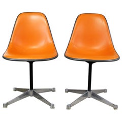 Paire de  Chaises Eames PSC pivotantes latérales tapissées de vinyle orange