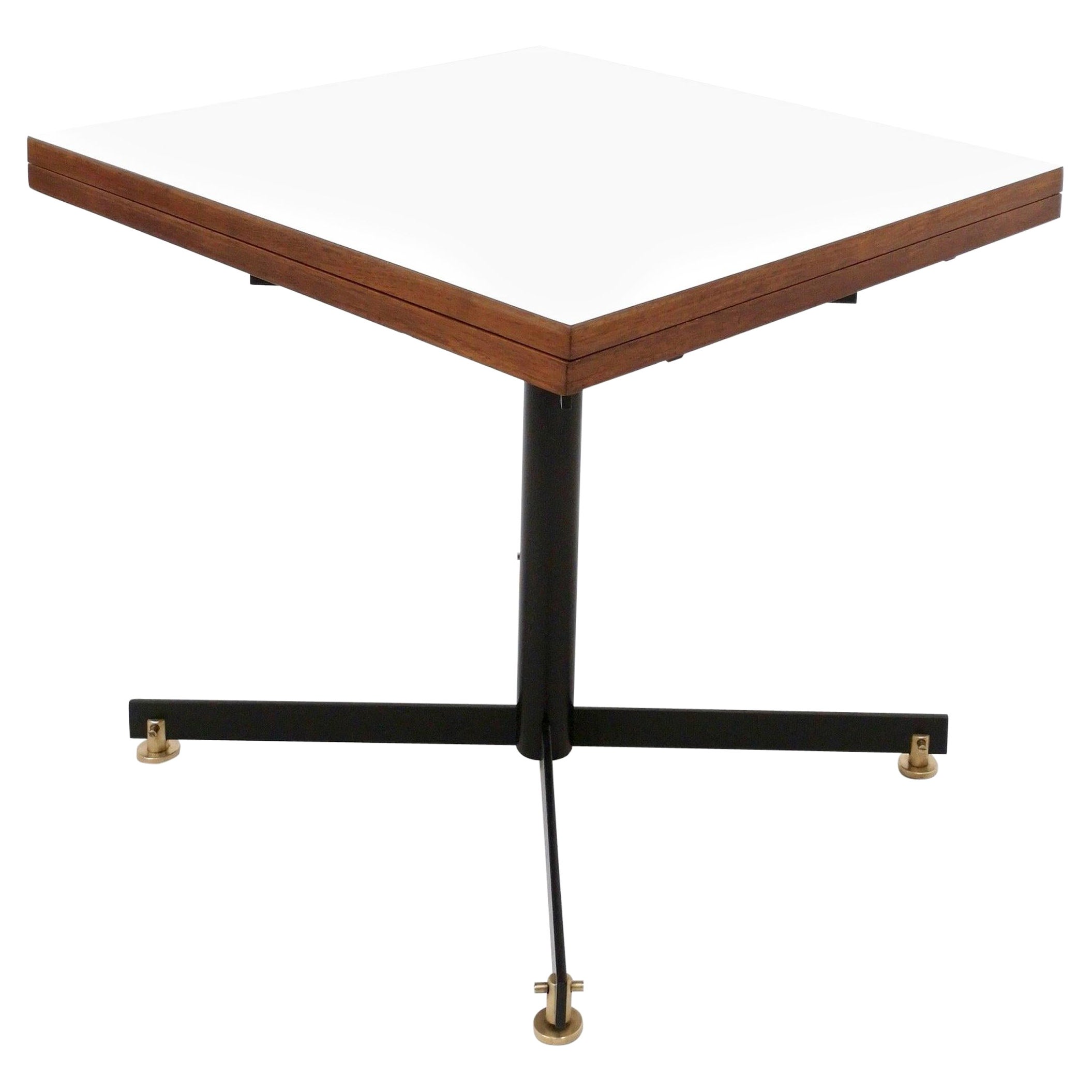 Made in Italy, 1950s.
This table is made in teak, black varnished metal and brass and its top is covered in white formica.
The opening mechanism works perfectly. 
It may show slight traces of use since it's vintage but it can be considered as in