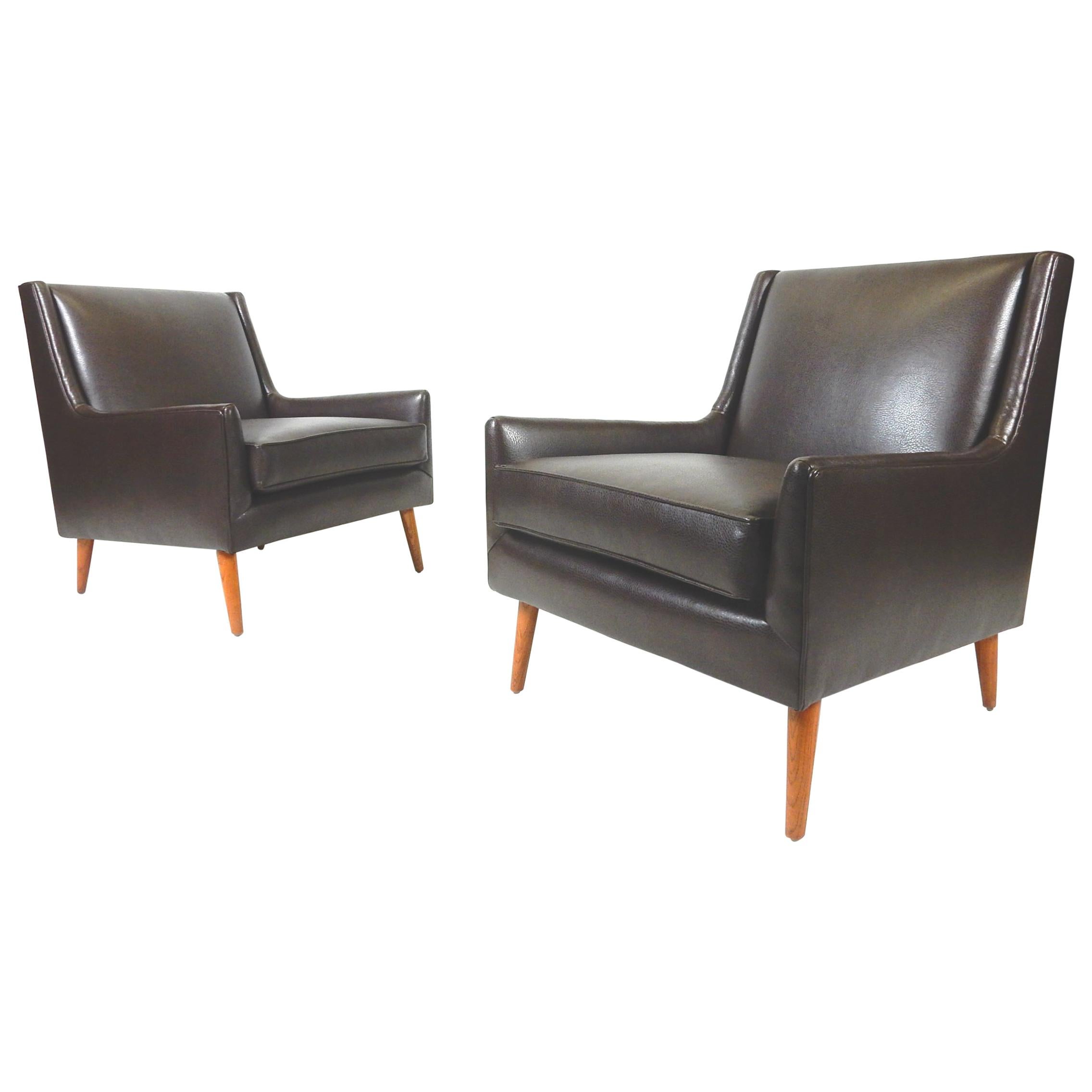 Incroyable paire de fauteuils de salon des années 1950 de style moderne du milieu du siècle qui ont été nouvellement recouverts d'un tissu d'ameublement.
Faux cuir fin et doux comme du beurre, de couleur marron chocolat.
Ils sont dans le style