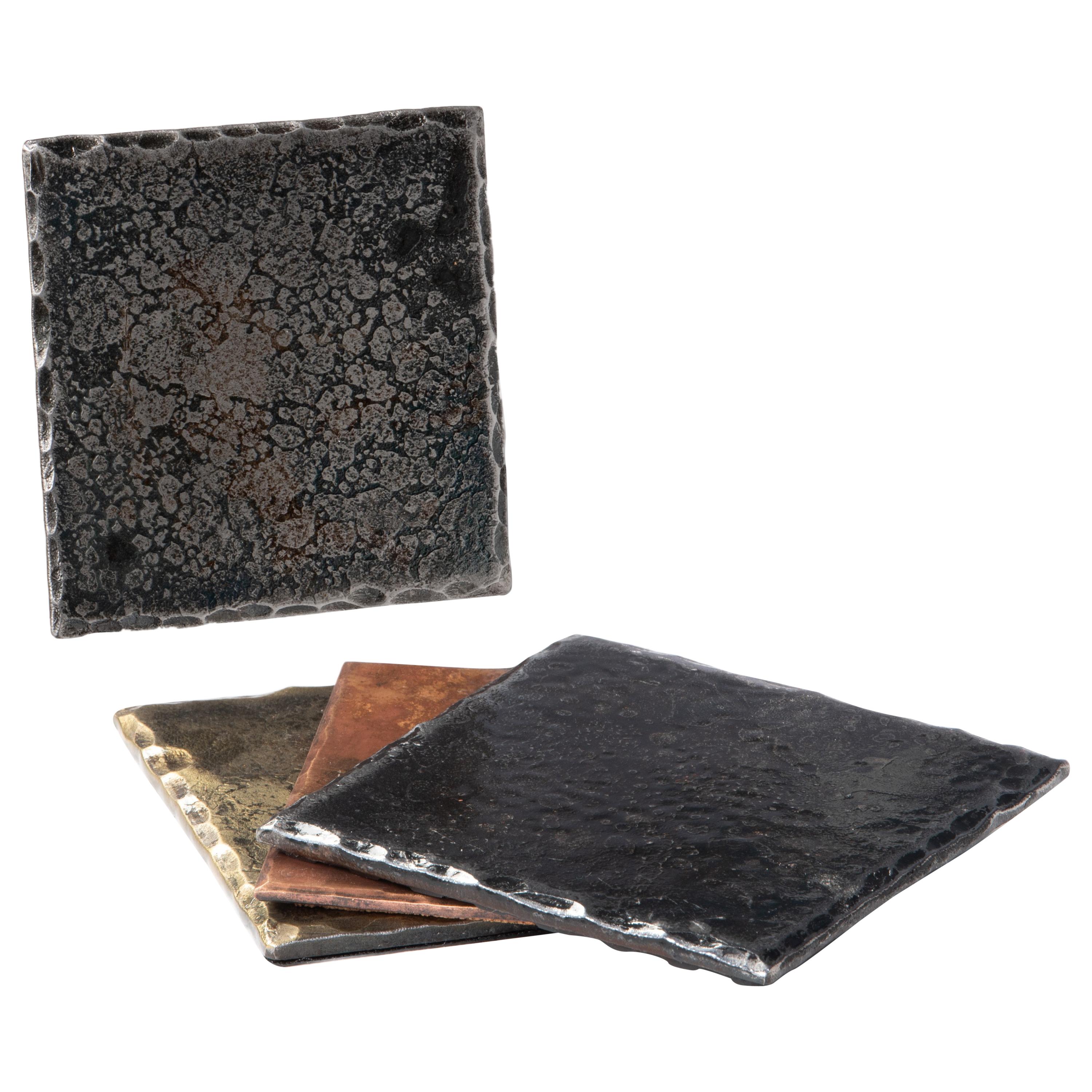 A handcrafted, steel square coaster with hammered, beveled edges. Wire brushed and sanded to accentuate the forged details. A glossy clear coat enhances the richness of the finish and texture. Thin cork base. Sold as a set of 4.