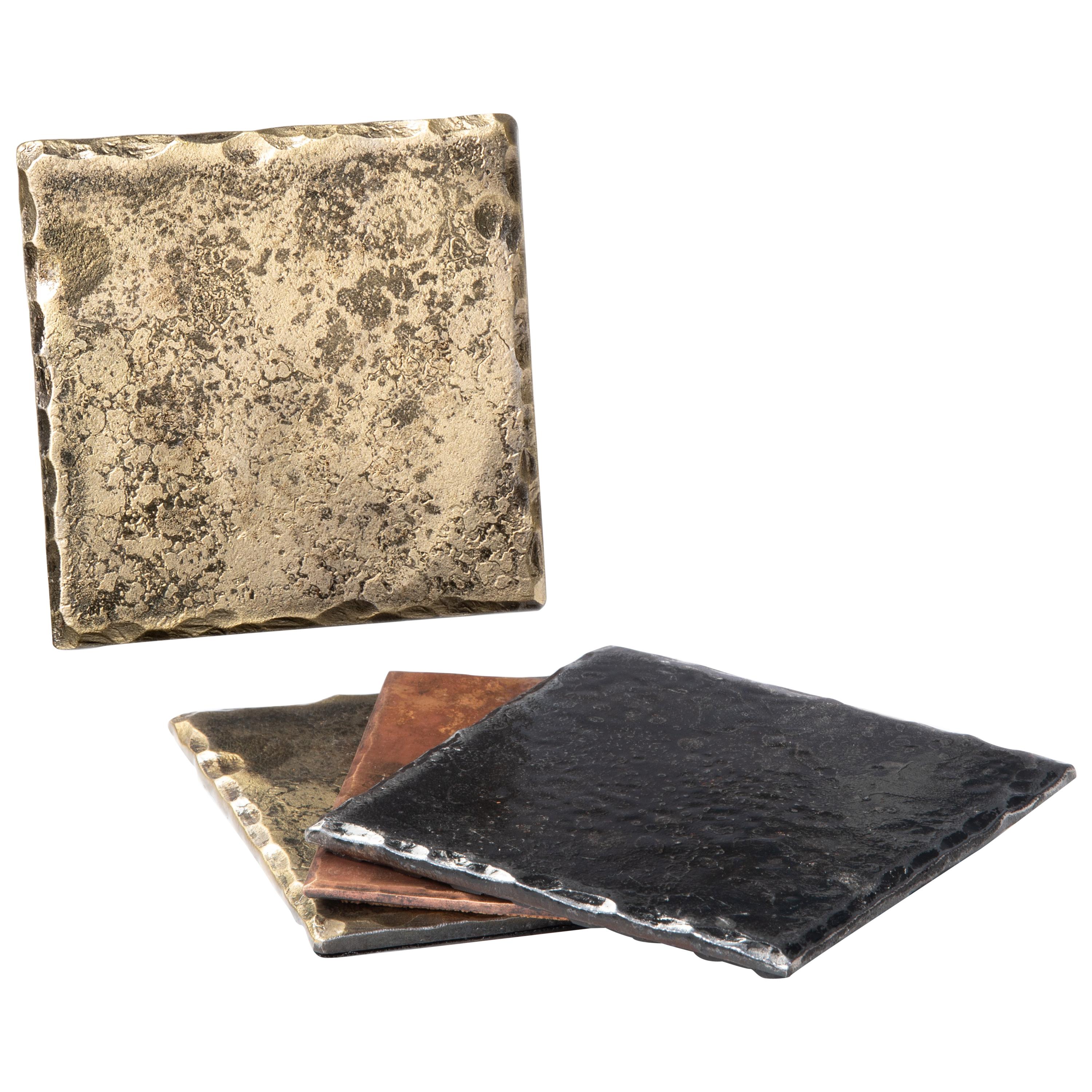 A handcrafted, steel square coaster with hammered, beveled edges. The rich gold tone is achieved through the use of a brass wire brush. A glossy clear coat enhances the richness of the finish and texture. Thin cork base. Sold as a set of 4.