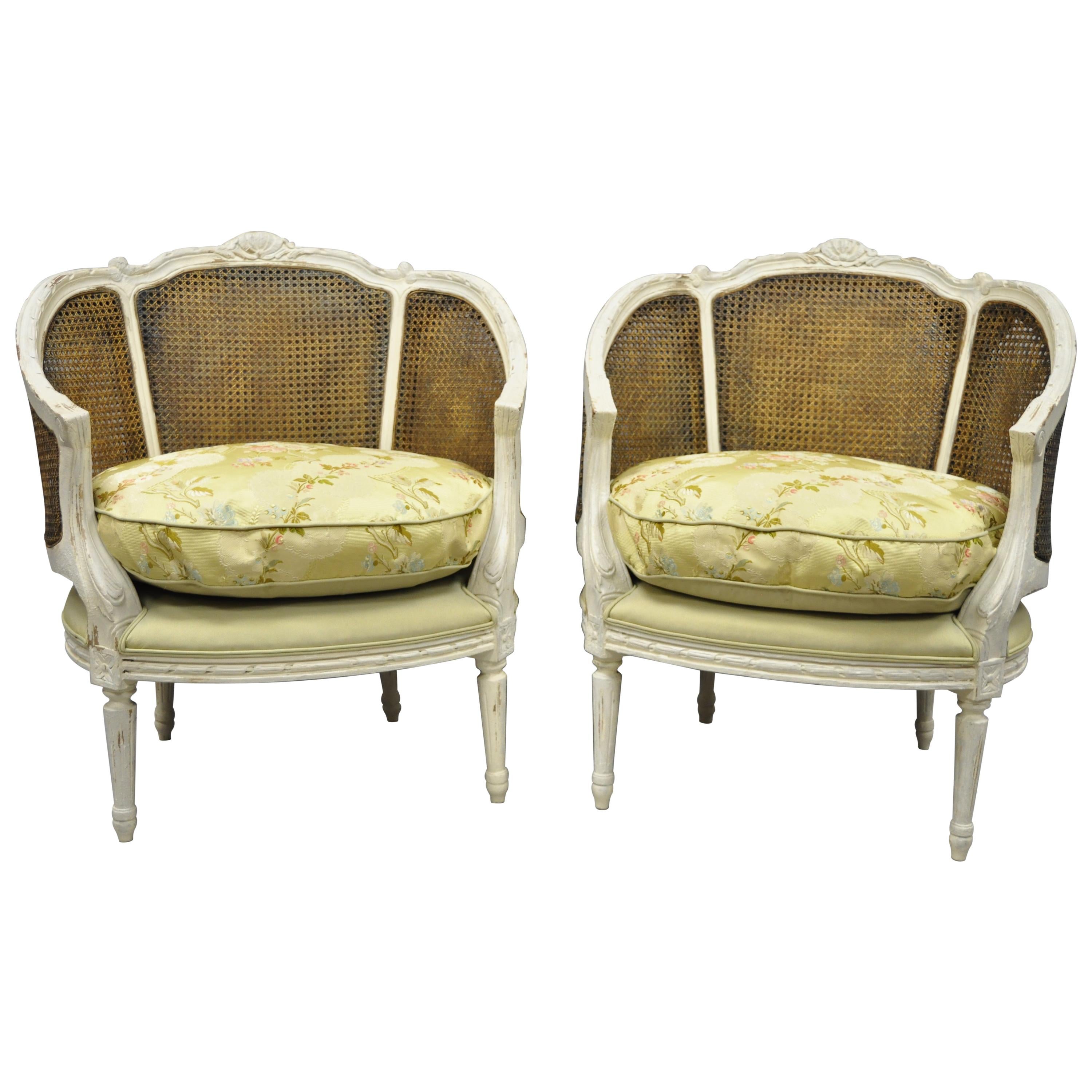 Paar französische Bergere-Salonstühle mit Rohrgeflecht im Louis-XVI.-Stil, weiß lackiert und im Distress-Stil
