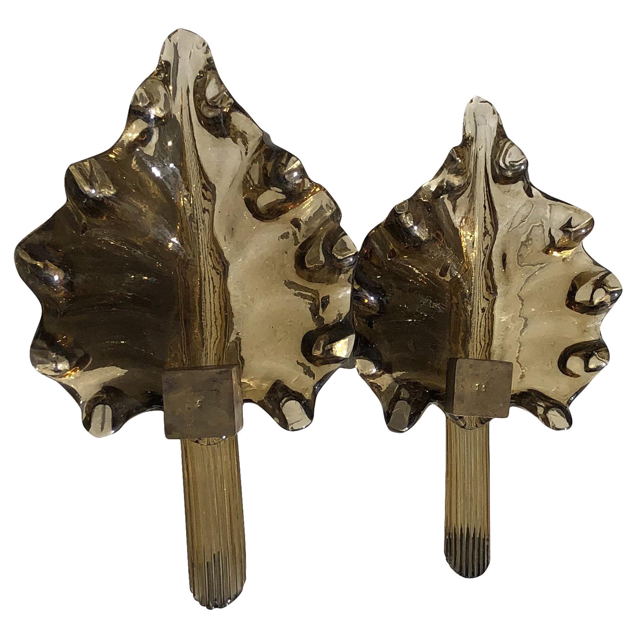 A gold, vintage Mid-Century Modern Italian leaf shaped pair of heavy Murano amber colored glass sconces with leaf decor, each lamp is featuring a one light socket. The wall lamps, lights are in good condition. The wires have been renewed. Wear
