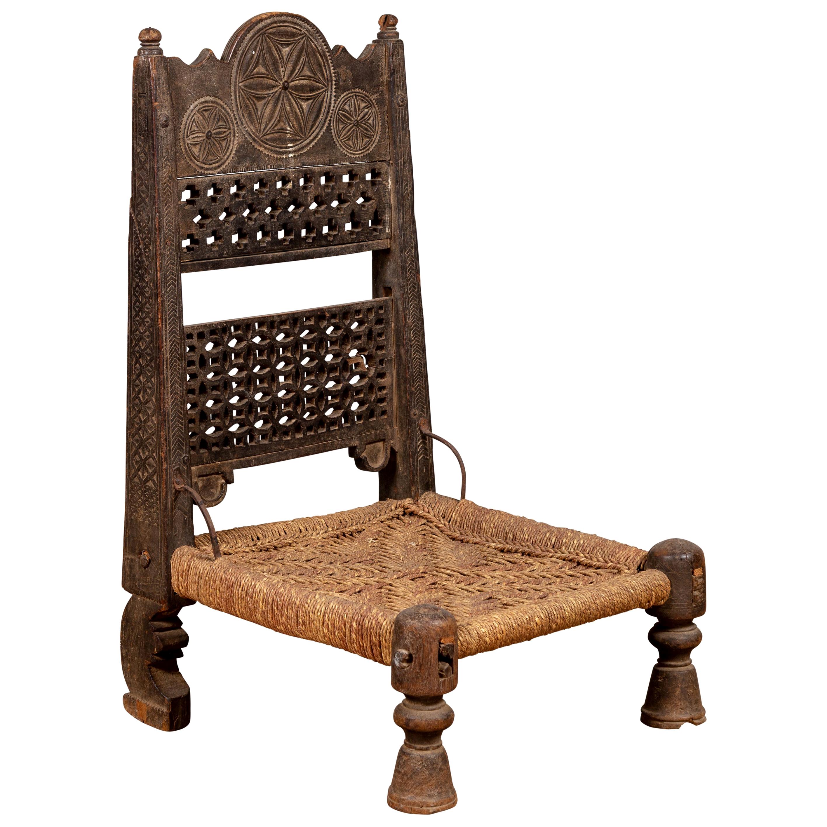 Ancienne chaise indienne rustique à assise basse en bois avec accents chantournés et rosettes
