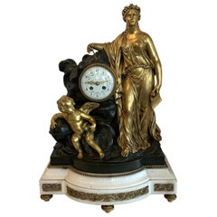 Grande horloge de style Régence en marbre doré, bronze patiné et bronze doré représentant une jeune fille chérubin