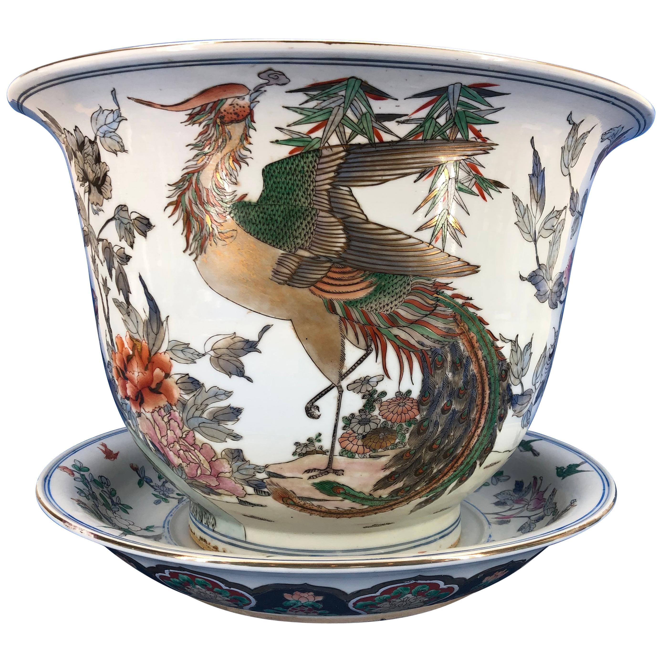 Large Chinese hand painted porcelain jardinière urn and charger

Porcelain is decorated with beautiful scenes of cranes, birds, flowers and acanthus leaves. Colors are green, red, orange, gold and blue.