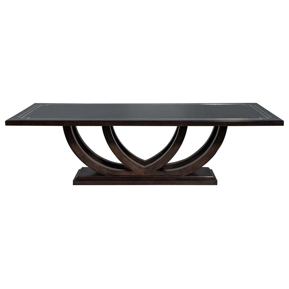 Mesa de comedor de nogal a medida con detalles incrustados de metal pulido y base curvada
