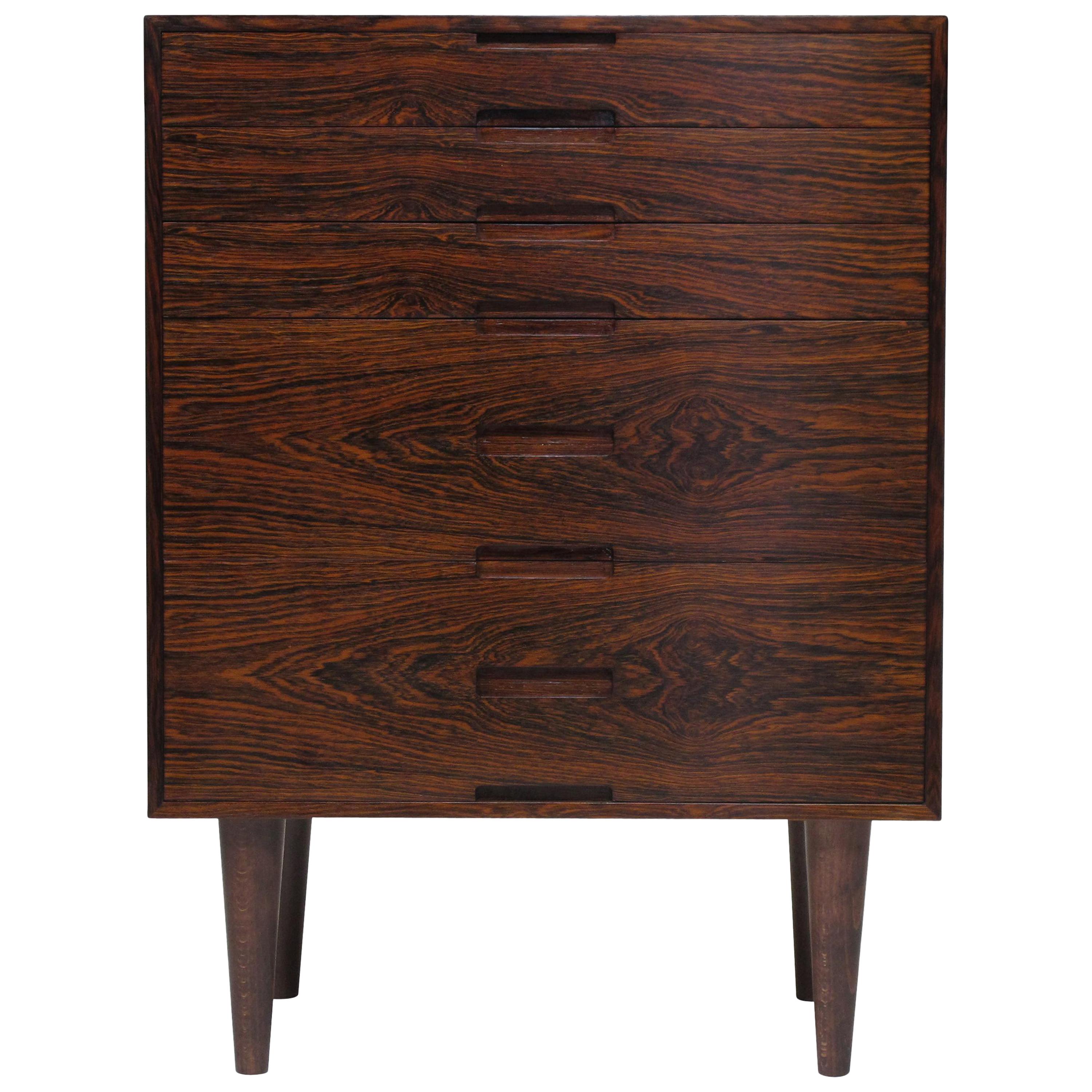 Pair of midcentury chest of drawers handcrafted of dark Brazilian rosewood. Each with mitered corners and series of five drawers with inset pulls, raised on tapered legs. Dynamic grained rosewood with pattern match down front of drawers. Interior