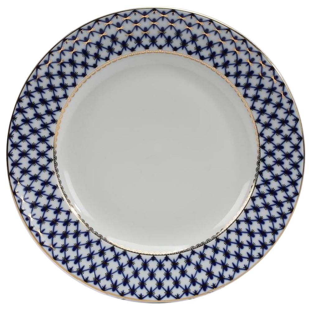 Russian Lomonsov porcelain service for eight in the cobalt net pattern, each piece decorated with a hand painted cobalt net having gilt accents, comprising. Measures: (8) dinner plates, 10.75