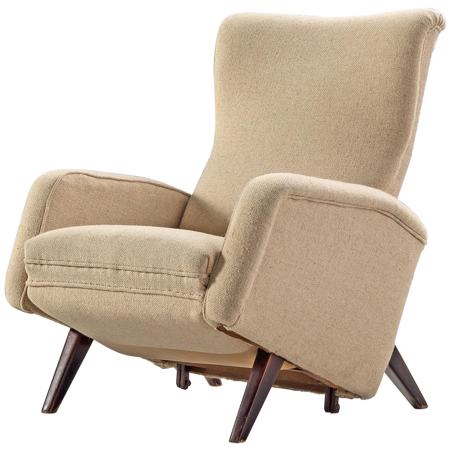 Armchair, beige fabric, wood, Italy, 1950s.

This lounge chair is voluptuous and grand as it's comfortable. The back is flexible and there is a small foldable foot element at the bottom of the chair with a leather patch to protect the fabric. The