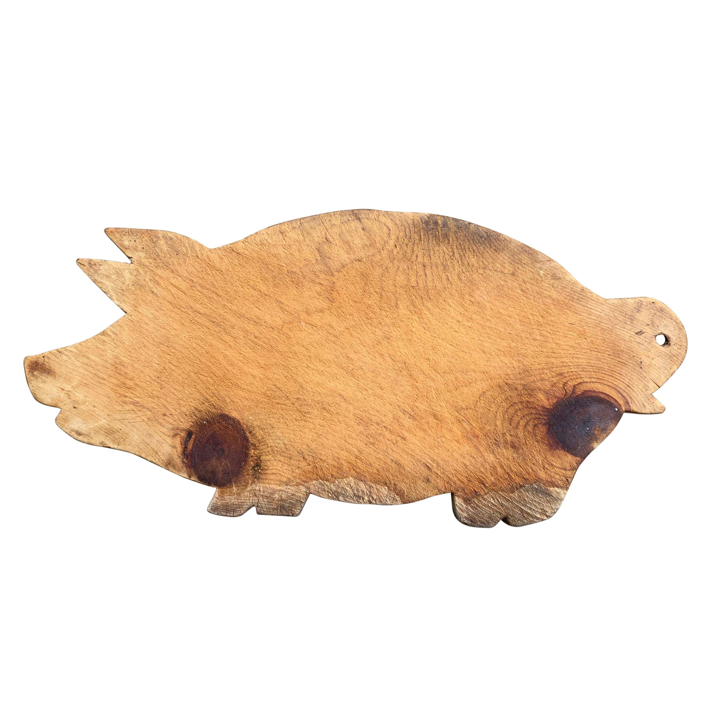 An assembled set of six early and mid-20th century American carved pine and maple pig cutting boards, some with ring tails, one with a studded eye, and all with wonderful patina and wear. These would be great hung on a wall in the kitchen, and/or