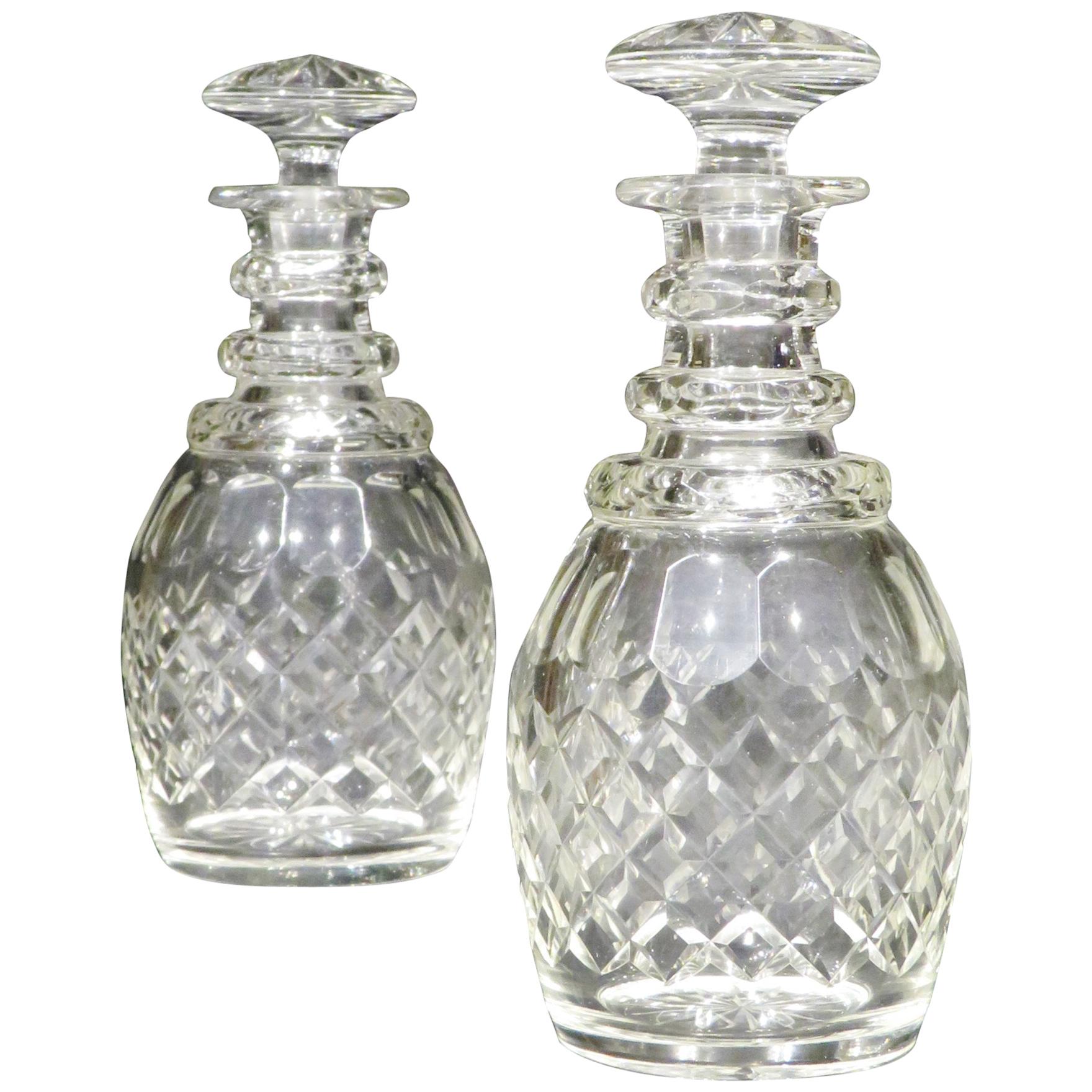 Both ovoid glass bodies exhibiting a slight greyish hue that is consistent with the period, decorated with scalloped & diamond cut detail, rising to faceted ringed necks fitted with their original dedicated and numbered mushroom stoppers, the
